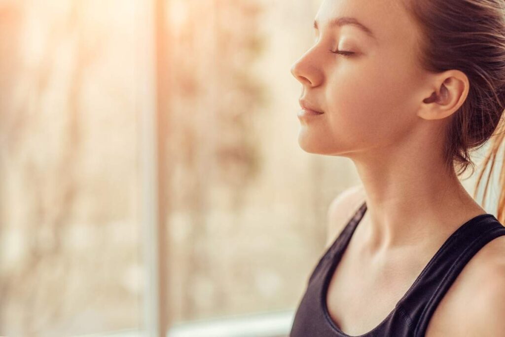 woman with closed eyes practicing deep breathing to relieve stress