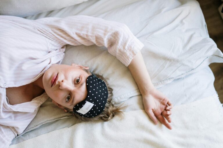Woman lying in bed staring at the ceiling, struggling to sleep – a common scene before applying steps to beat insomnia.