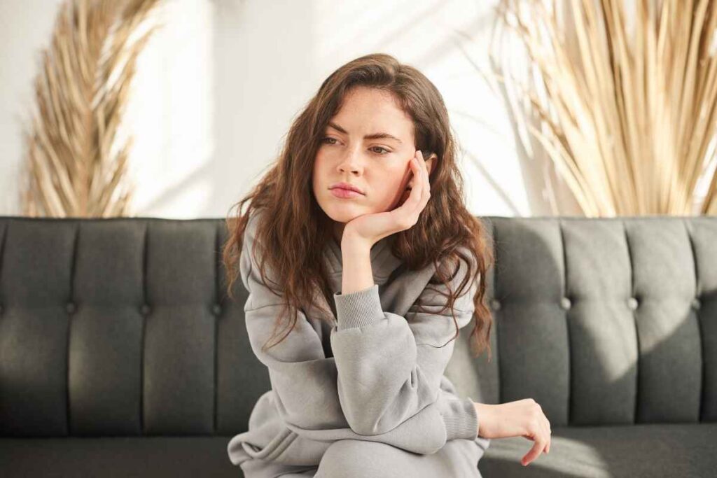 thoughtful woman reflecting on her inner dialogue, practicing how to reframe negative self-talk