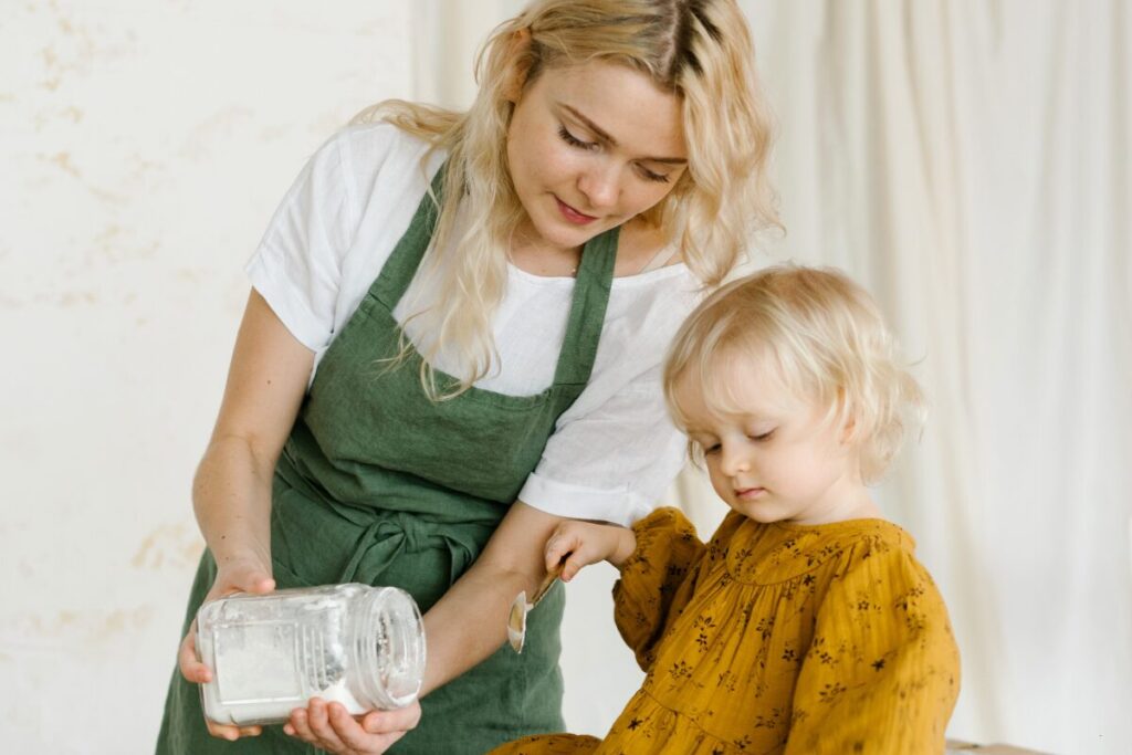 woman cooking with her toddler at home, balancing family life and learning to be productive at home