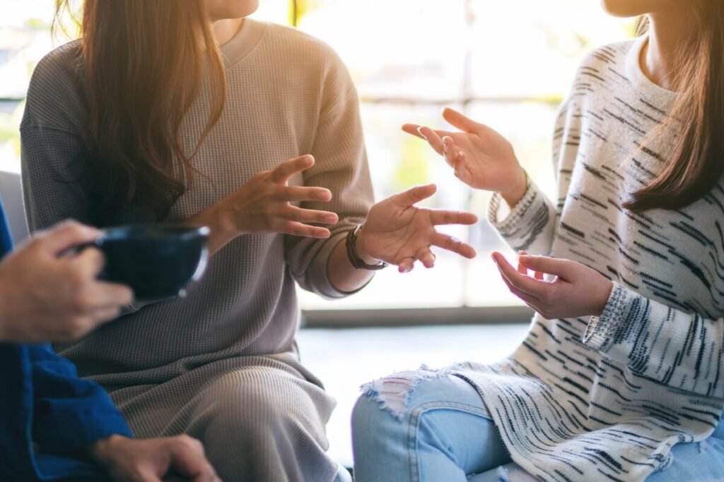 Two people gesturing with hands during a discussion about setting healthy boundaries