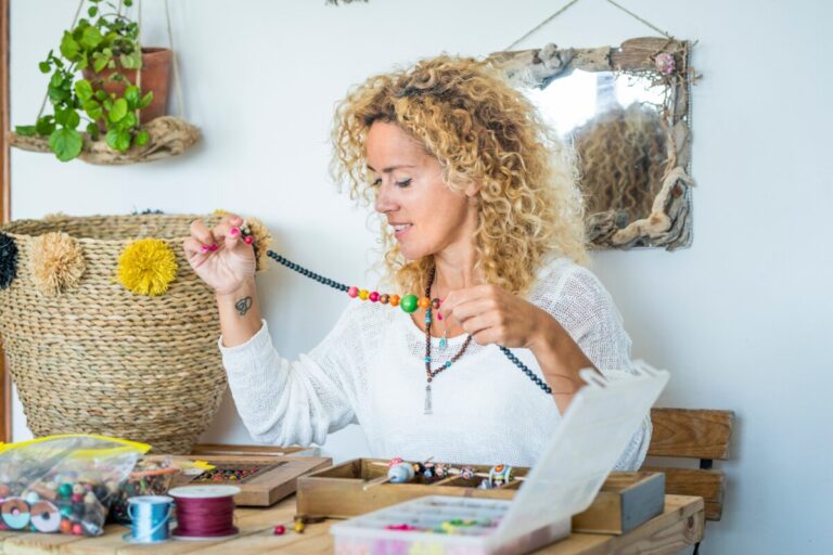 woman making a beaded necklace, practicing creativity to get out of her comfort zone