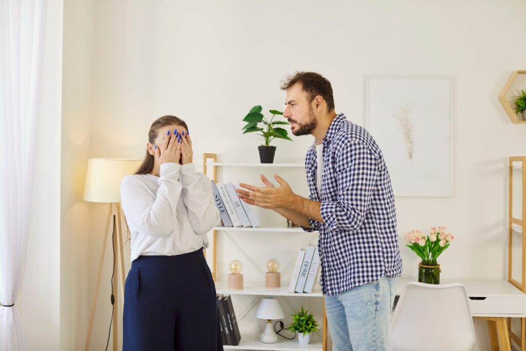 Woman covering her face while man explains – dealing with jealousy in a relationship