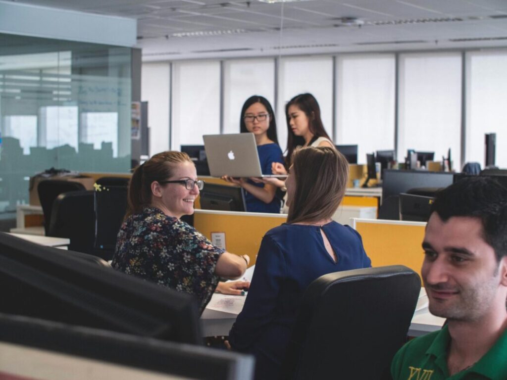 Team collaborating in an office, demonstrating ways to improve focus at work together efficiently.