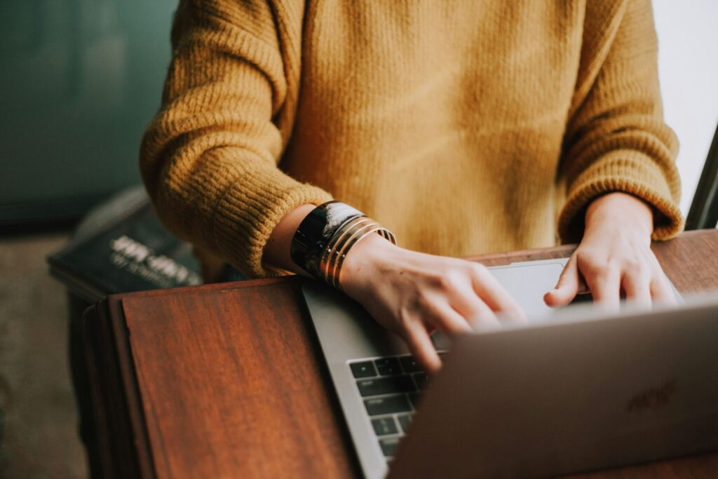 Woman working on a computer, focusing on productivity without stress, demonstrating ways to let go of perfectionism and embrace progress over perfection.