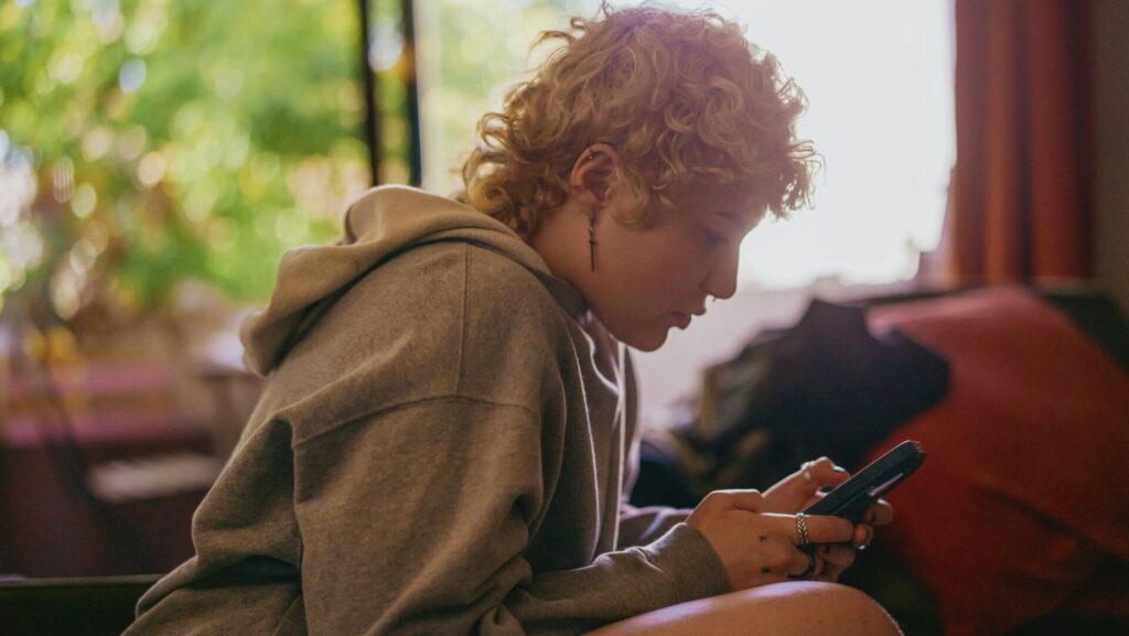 Woman scrolling on her phone with lack of focus, reflecting everyday struggles connected to adult ADHD symptoms.