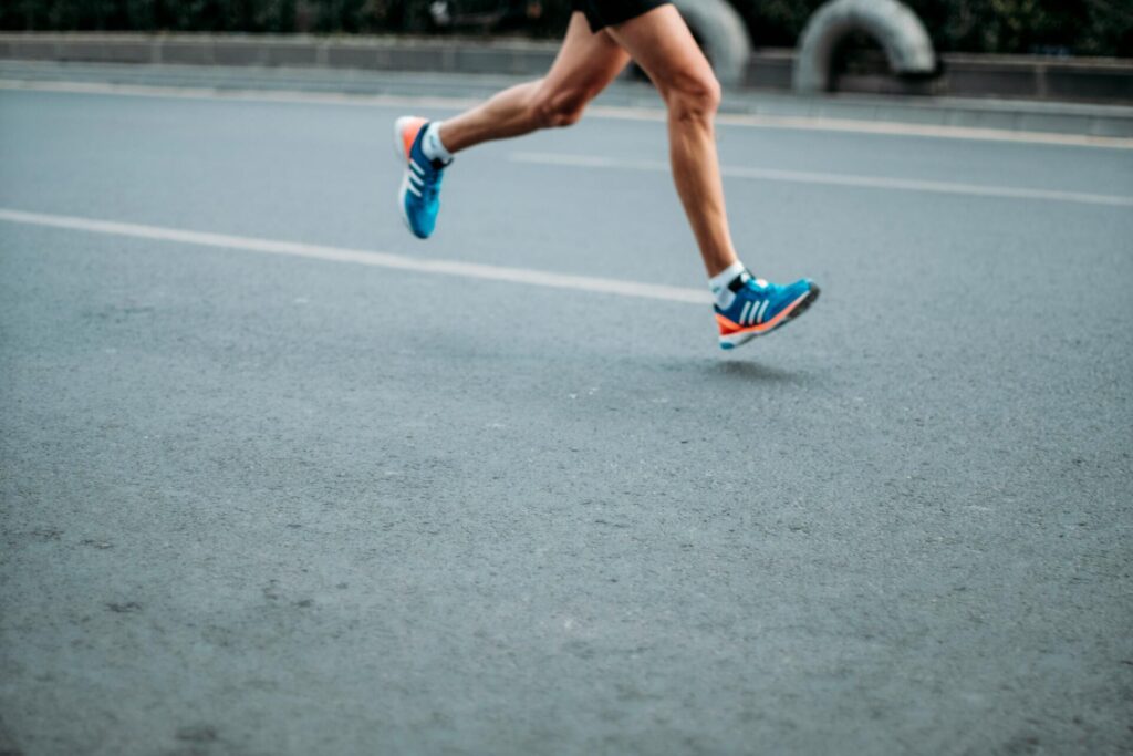 Brain-boosting physical activity — close-up of a man’s legs mid-run, showing how regular cardio exercise helps improve memory and cognitive function.