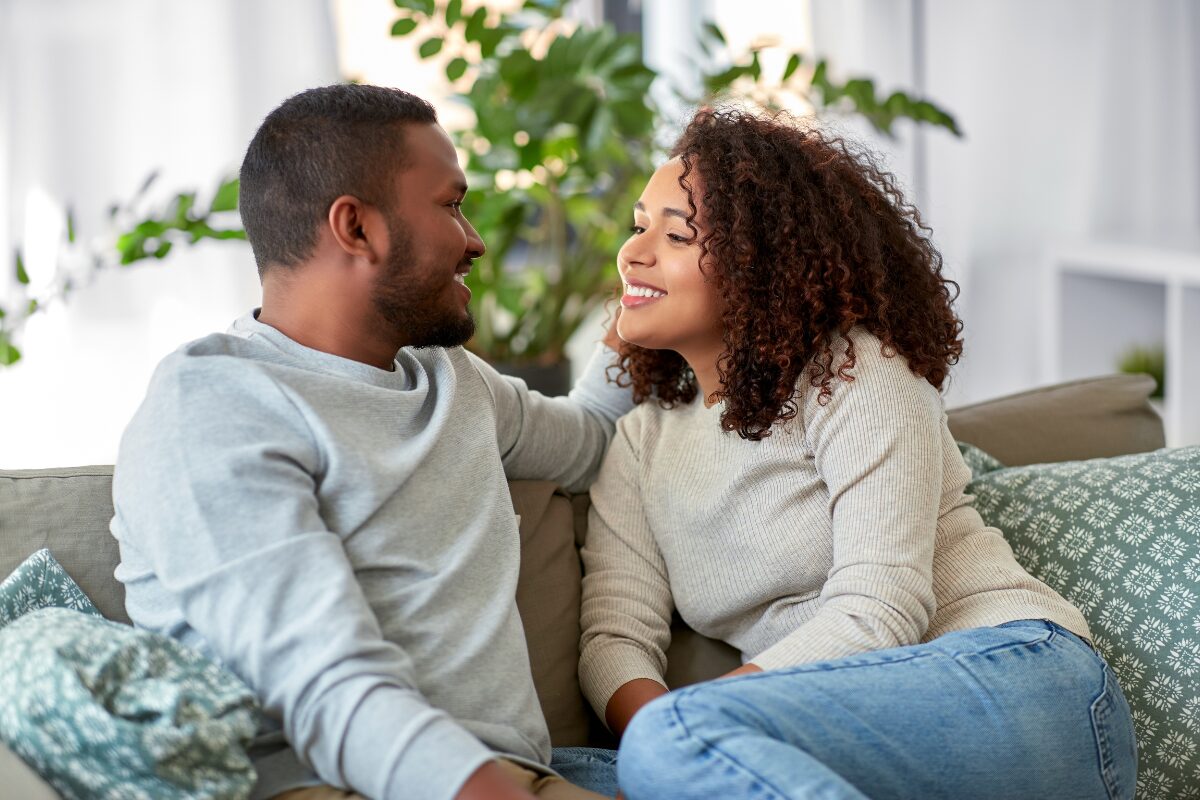 couple talking on a couch at home improving communication skills in a relationship