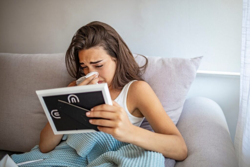 woman crying holding photo after breakup