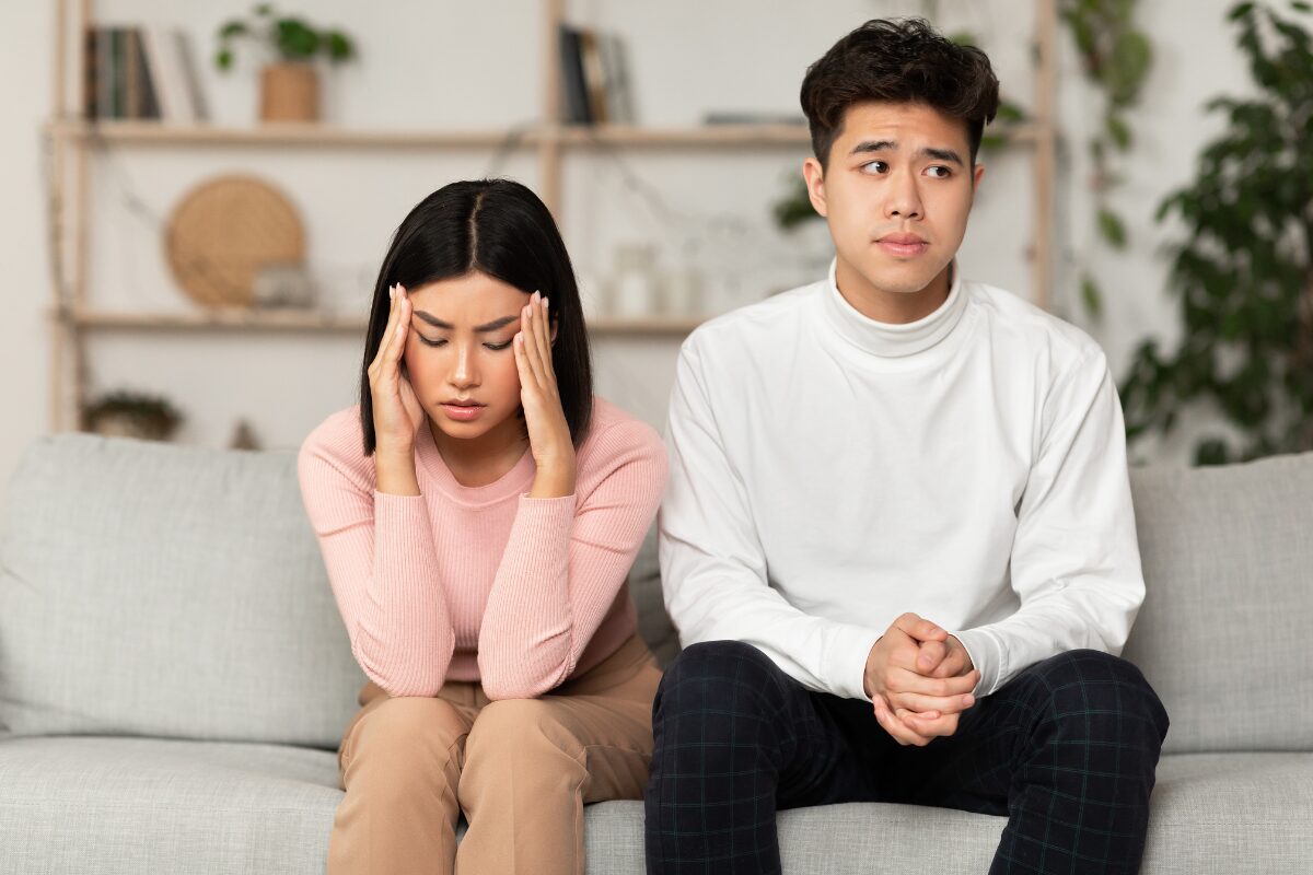 signs of an emotionally unavailable person couple sitting apart on couch feeling distant
