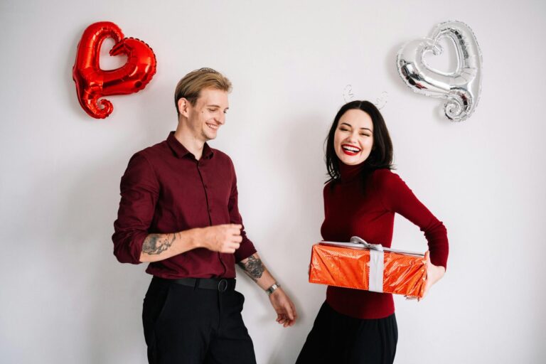 Happy couple smiling and holding balloons, perfect image to illustrate Romantic Short Valentine's Day Verses full of love and joy.