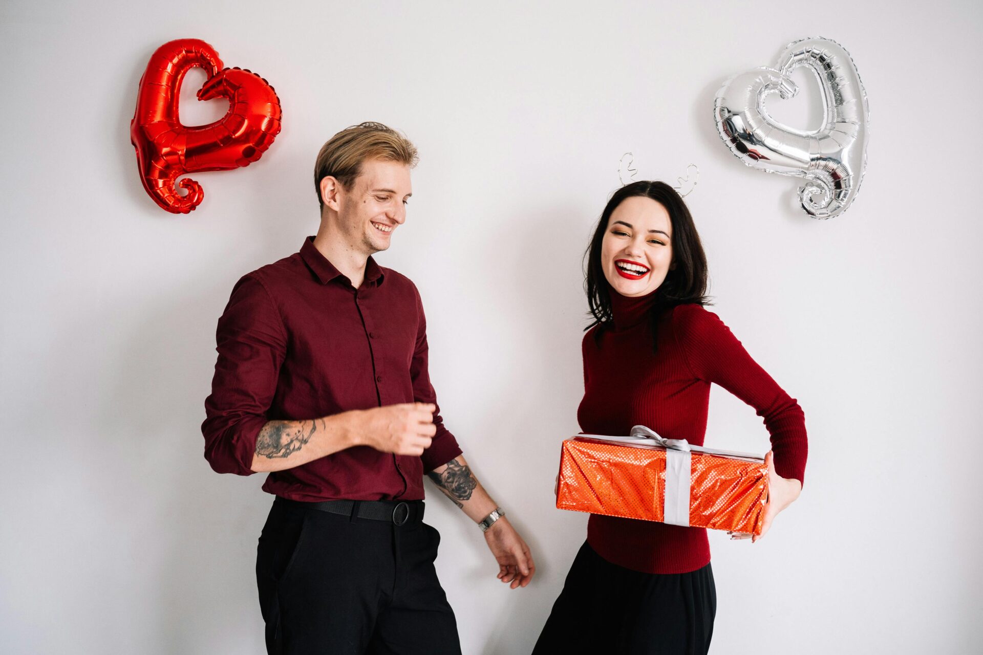 Happy couple smiling and holding balloons, perfect image to illustrate Romantic Short Valentine's Day Verses full of love and joy.