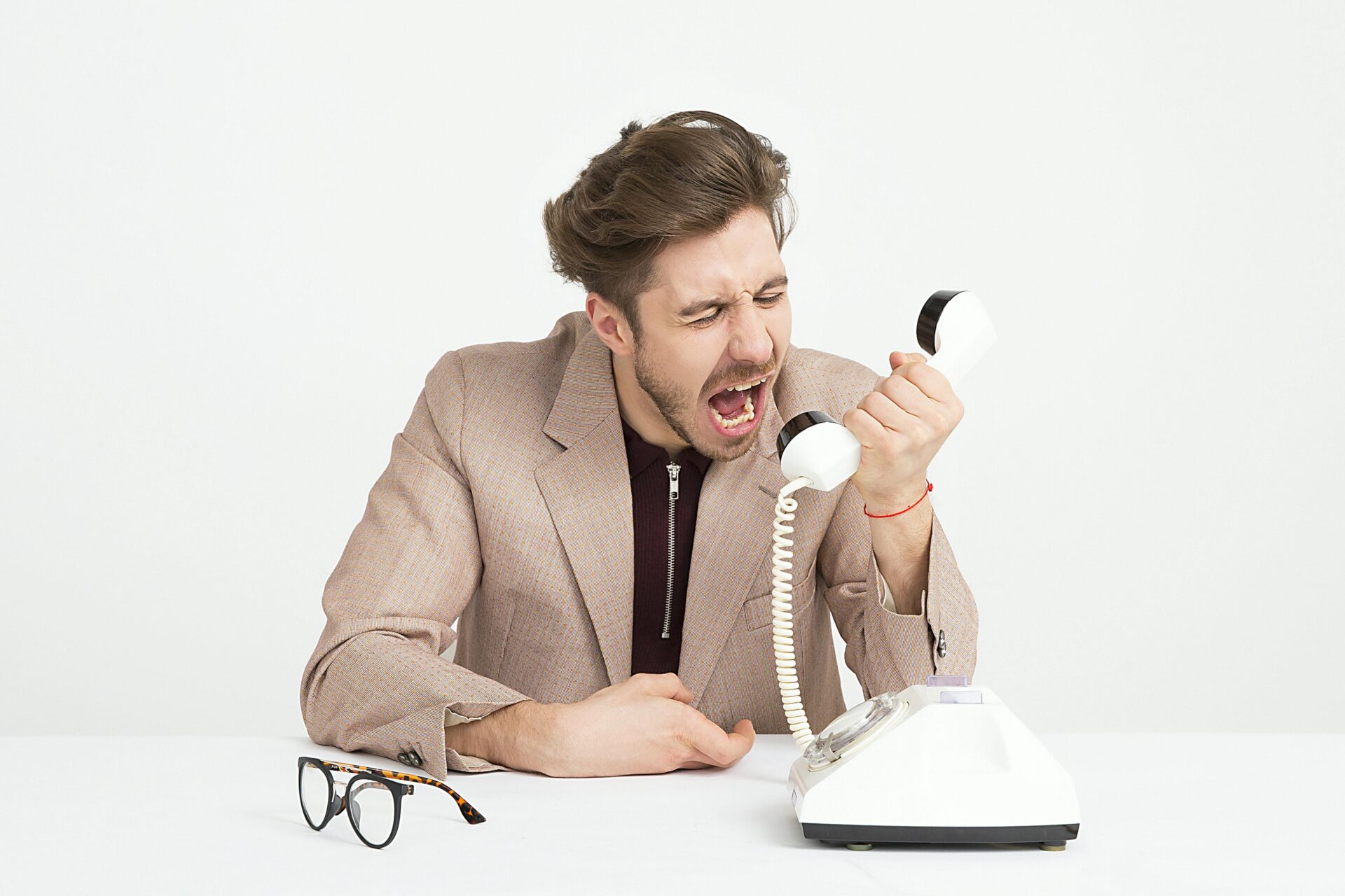Angry man yelling into his phone, showing a need for techniques for effective emotion regulation during stressful moments
