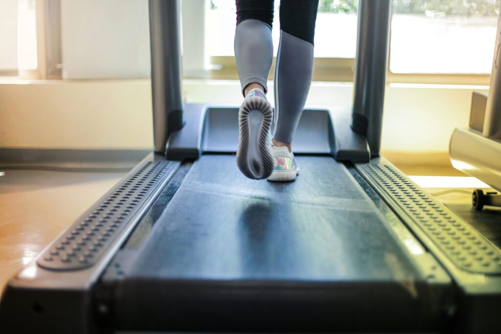 Woman walking on a treadmill—capturing the fleeting motivation behind fitness goals and why New Year's resolutions fail.