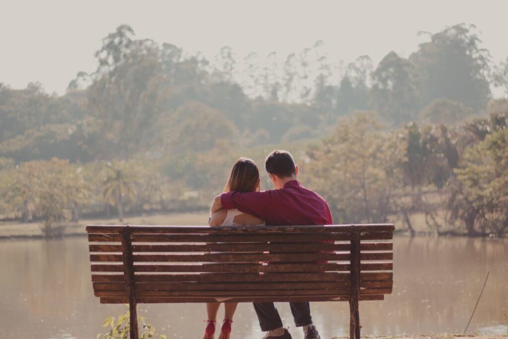 couple sitting on a bench in nature
