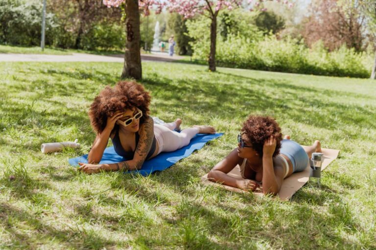 why you can't change people - Two women are talking while lying on the grass in the park.