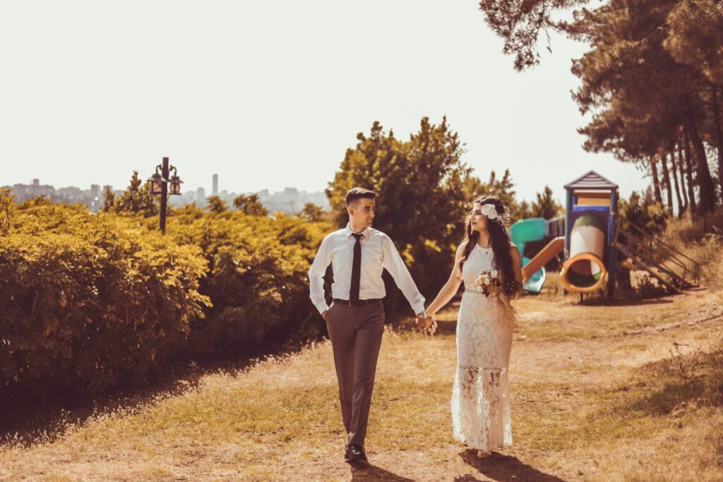 Just-married couple walking hand in hand in nature, looking into each other’s eyes—showing emotional connection and signs you are ready for marriage.

