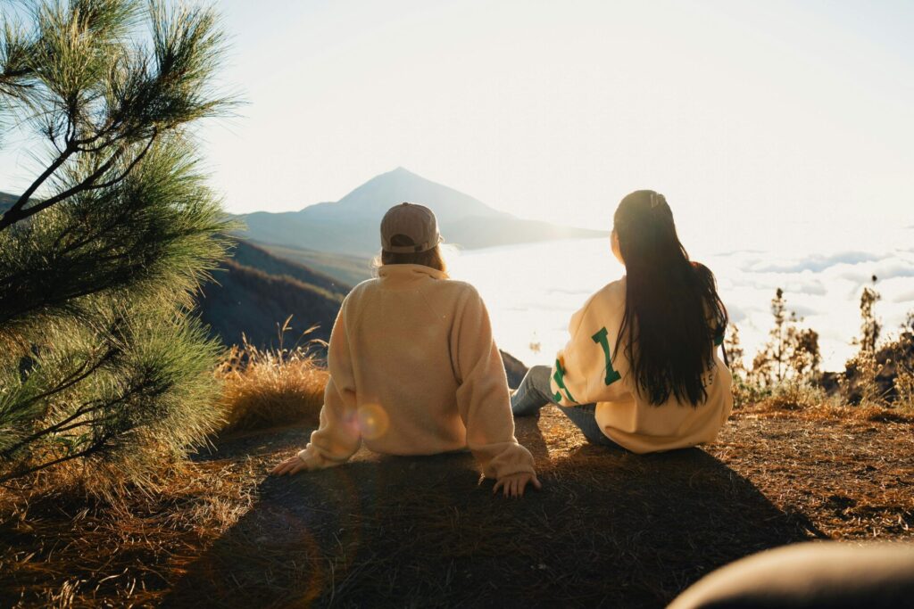 Two close friends talking while enjoying a scenic view—reflecting on deep thoughts like Why do I apologize so much during honest conversations.