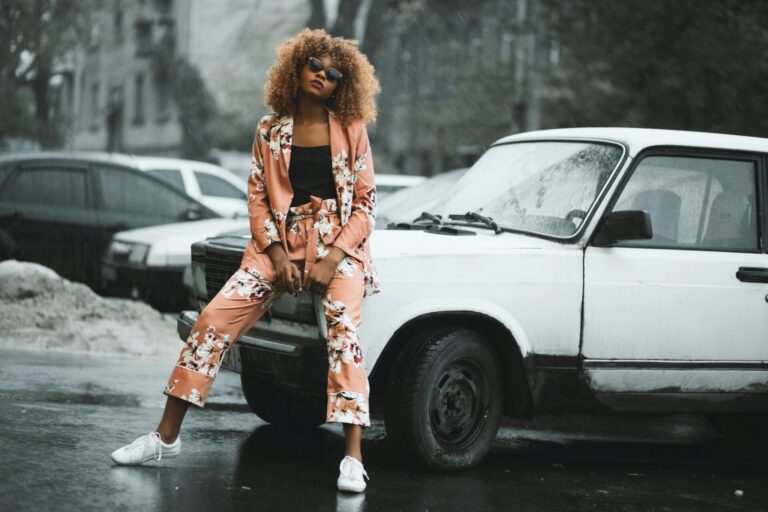 Stylish woman leaning confidently against a car, embodying how to be a confident woman in a relationship