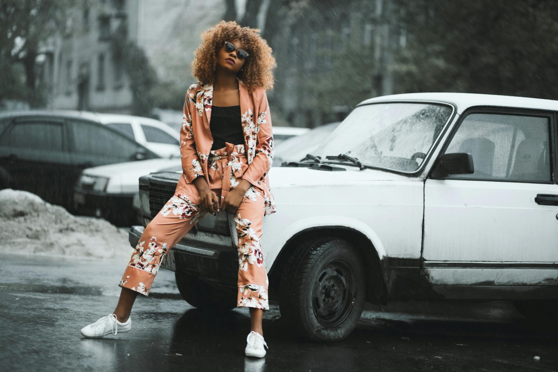 Stylish woman leaning confidently against a car, embodying how to be a confident woman in a relationship