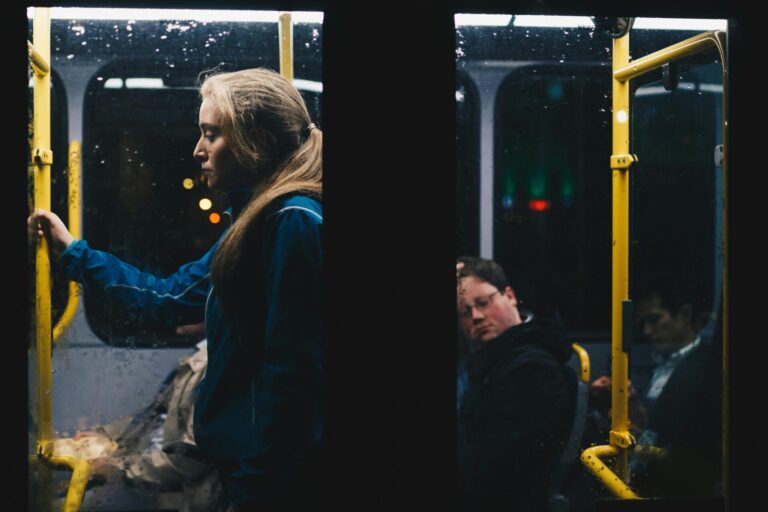 Woman standing alone on a crowded train, looking thoughtful and sad, reflecting on how to deal with loneliness after a breakup.