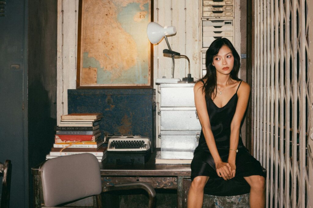Woman sitting at a desk, deep in thought and processing emotions, exploring how to improve yourself after a breakup.