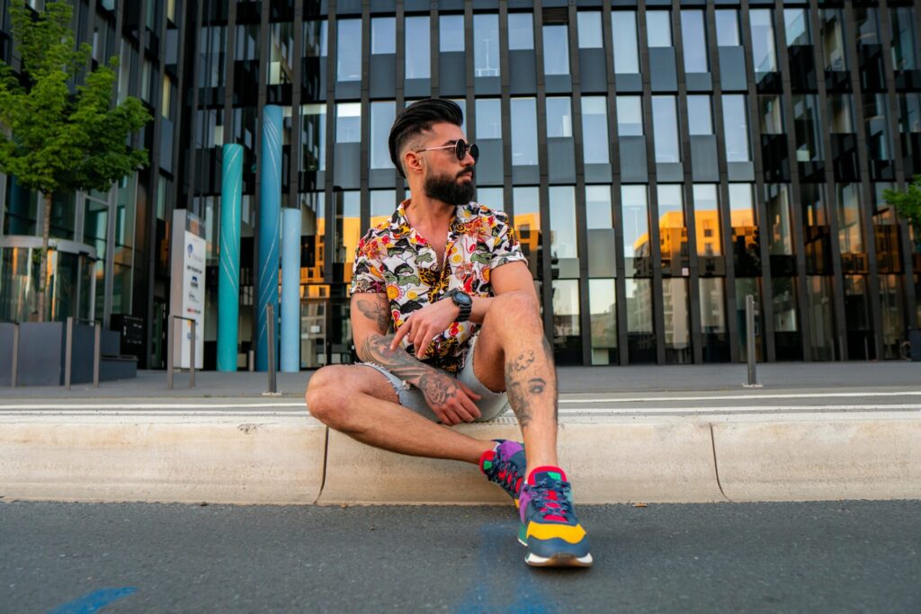 Man sitting thoughtfully on outdoor stairs in front of a building, reflecting on how to improve yourself after a breakup.
