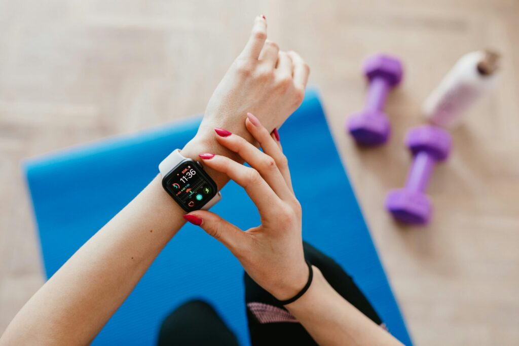 Girl exercising on a workout mat, checking her smartwatch, showing common reasons why you don't achieve goals