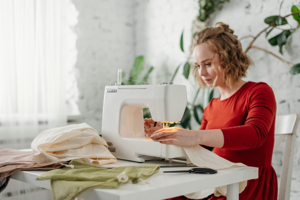Woman sitting and sewing on a sewing machine, illustrating one of the reasons why you don't achieve goals.
