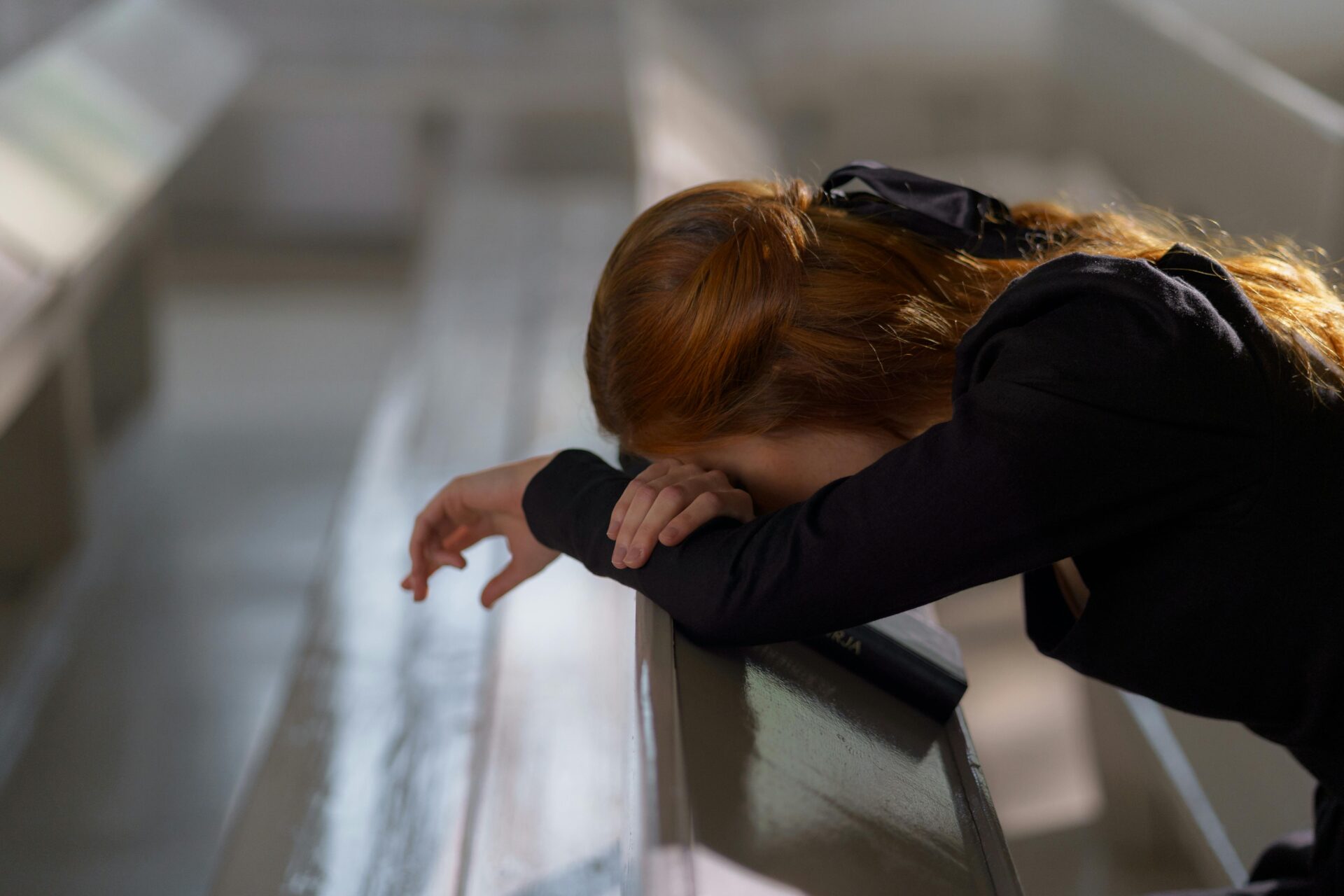 "Woman sitting alone, leaning on a bench and looking down, reflecting signs of fear of commitment in relationships such as doubt, anxiety, and emotional overwhelm.