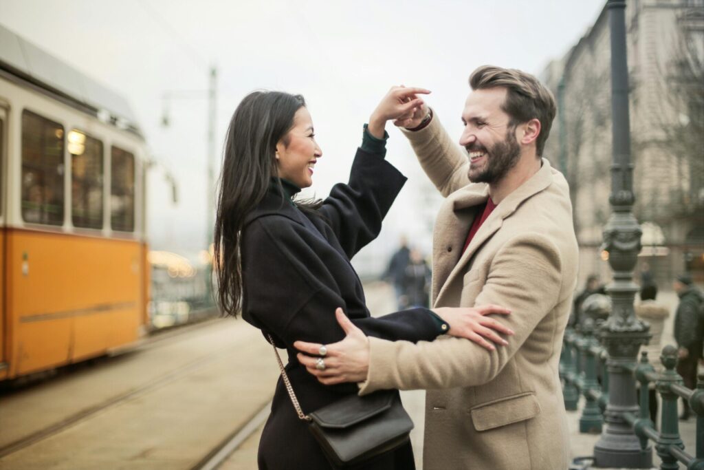 Happy couple dancing outdoors, with hidden signs of fear of commitment in relationships often masked by fun and laughter.