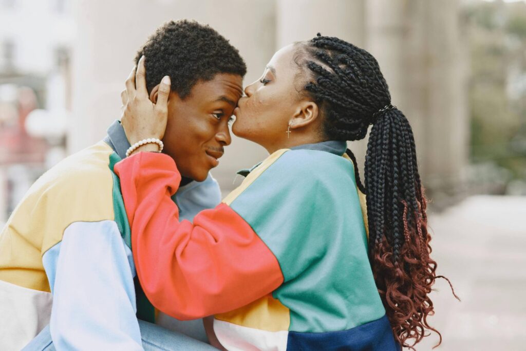Woman gently kissing her partner’s forehead, symbolizing love and growth on the journey of how to stop being controlling in relationship.

