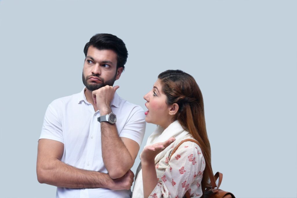 Woman expressing frustration while the man looks away silently, showing moments when taking things personally can harm your relationship.

