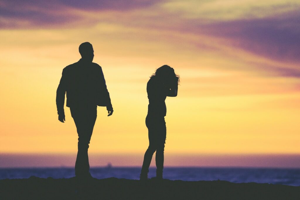 A couple is having difficulties, with a sunset in the background.

