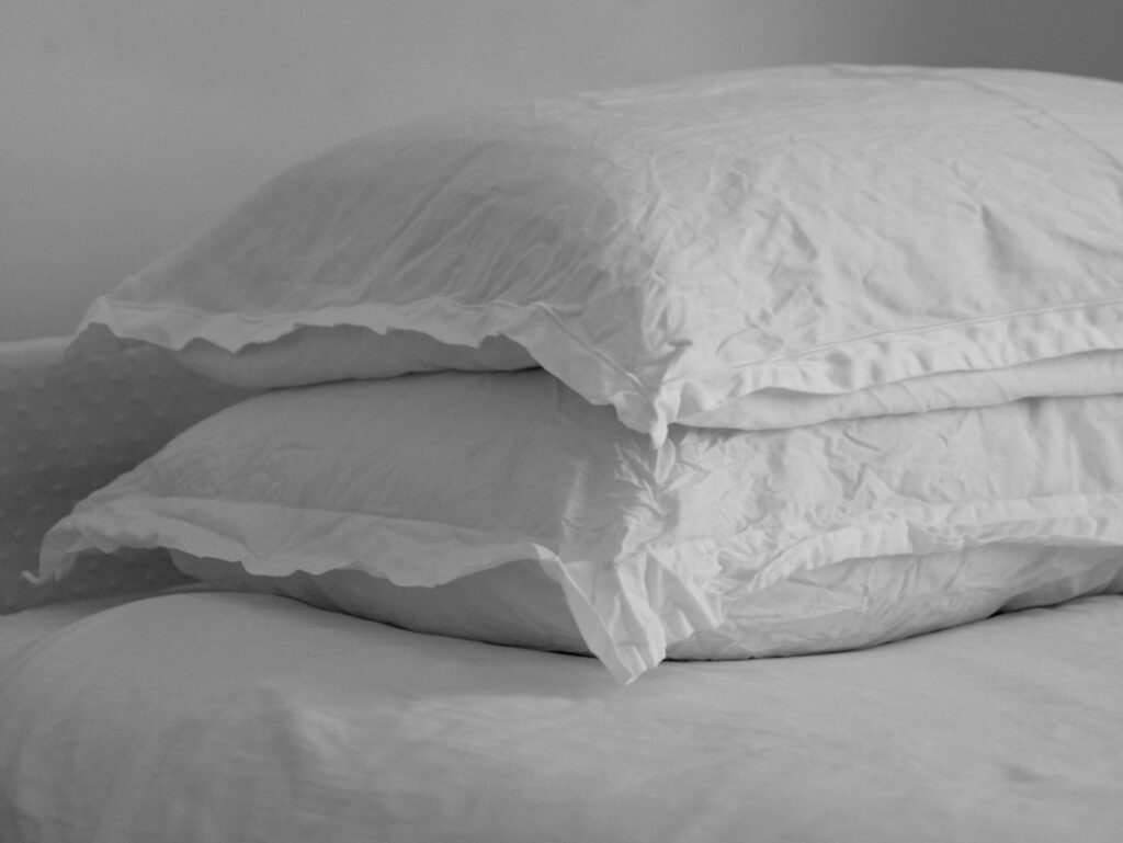 Morning grounding routine — cozy white bedding with two pillows symbolizing rest, comfort, and a calming morning atmosphere.