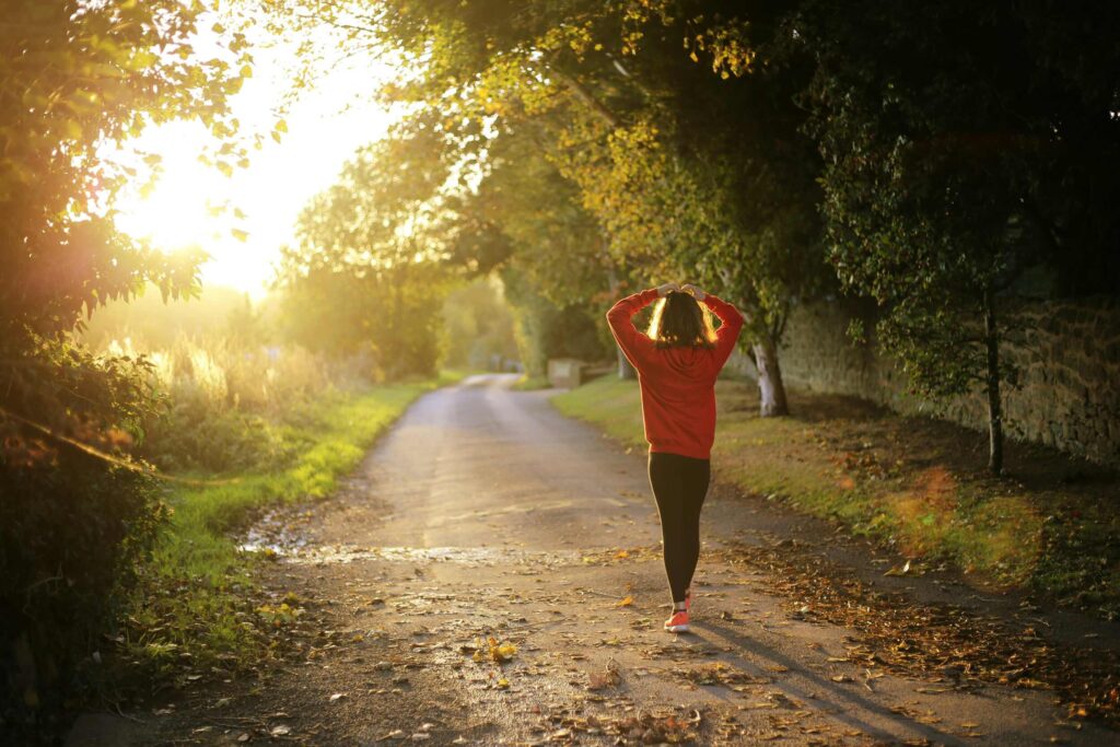 How to start your day feeling calm — woman on a peaceful early morning walk outdoors, connecting with nature to feel more grounded.