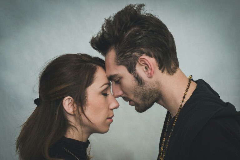 A man and a woman are leaning their foreheads against each other.