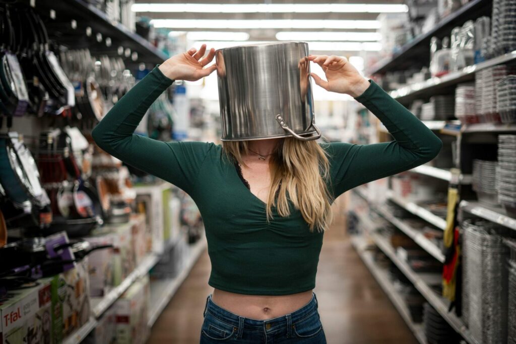 How to find clarity when you feel lost — girl in a grocery store playfully wearing a pot on her head, symbolizing emotional confusion and lack of direction.