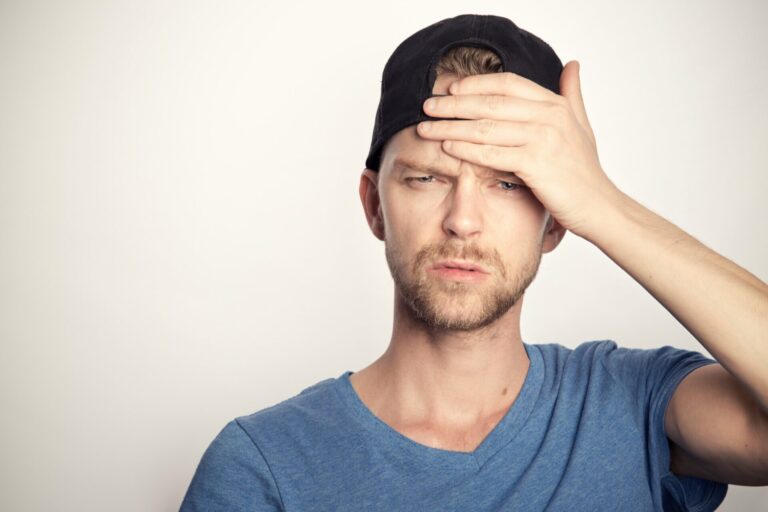 Questions to ask yourself when feeling lost — man looking confused and holding his forehead in frustration, unsure of what to do next.