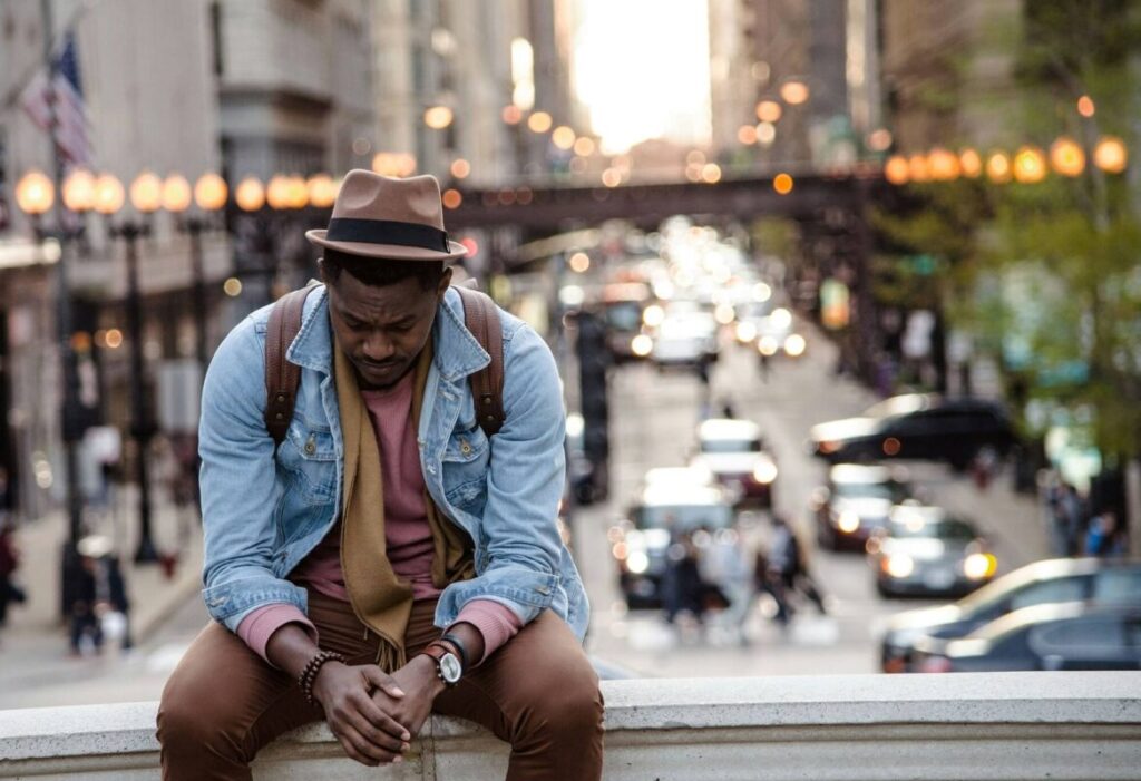Man sitting on a bench looking sad and thoughtful, contemplating questions to ask yourself after a breakup.
