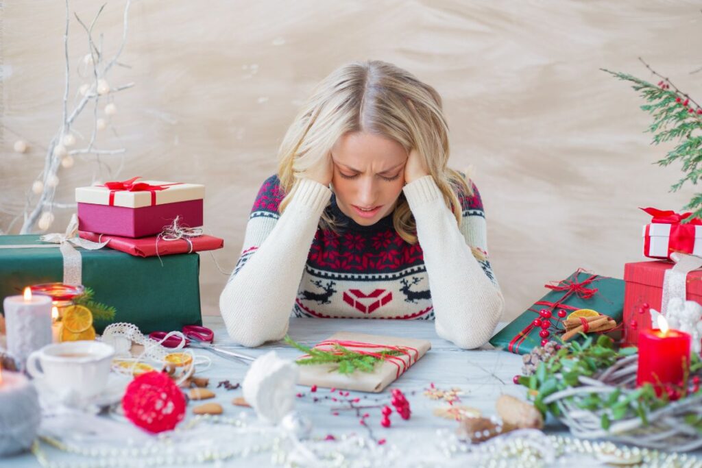 woman wrapping gifts feeling completely burned out, learning how to avoid holiday burnout
