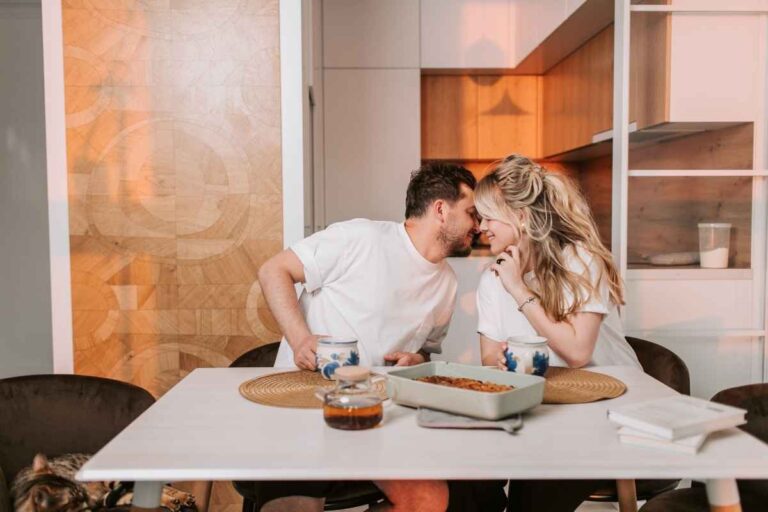 Signs you’re rushing into a relationship: a couple passionately kissing in the kitchen, illustrating intense early romance that may be moving too fast